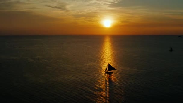 필리핀, 보르 카이 섬에서 일몰시에 배를 타고 바다로 가고 있었다. 아름다운 석양을 마주 하고 있는 범선. — 비디오