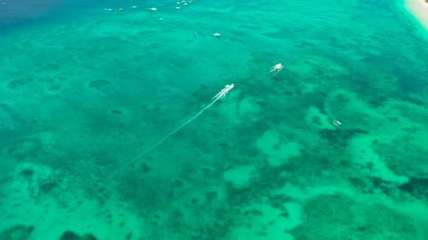 白い砂浜のボラカイ島、熱帯のビーチの近くの青いラグーンのスピードボート. — ストック動画