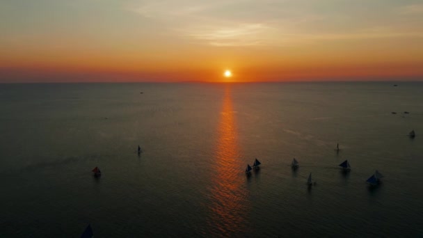 Filipinler 'in Boracay adasında gün batımında denizde yüzen tekneler. Günbatımına karşı yelkenli. — Stok video