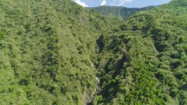 Dağlarda şelale. Yağmur ormanlı dağlar. Dağlar sık ormanlarla kaplıdır..