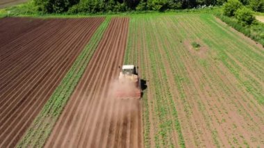 Patates tarlasında tarım makineleri toprağı işliyor..