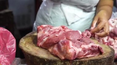Kasap bıçakla çiğ et doğruyor. Kasap elleri yakın: kesme buluşma