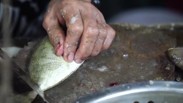 Mujer está cortando pescado en un mercado de mariscos. — Vídeos de Stock