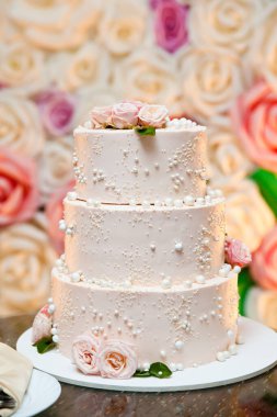 Düğün pastası. Güllerle süslenmiş beyaz pasta. Tatil için güzel bir tatlı.