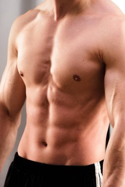 Eşofman lı genç fit adamın kırpılmış görüntüsü ab'yi esnetiyor