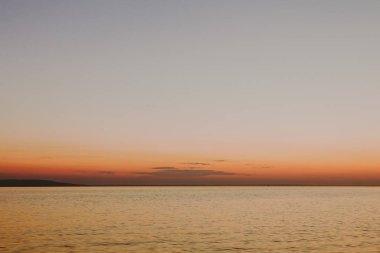 Arka planda gün batımı ile ipeksi pürüzsüz su