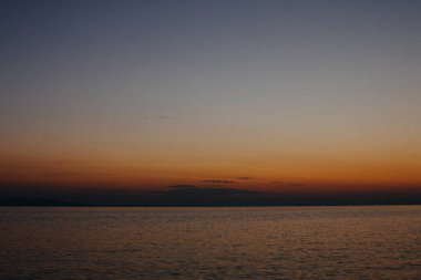 Arka planda gün batımı ile ipeksi pürüzsüz su