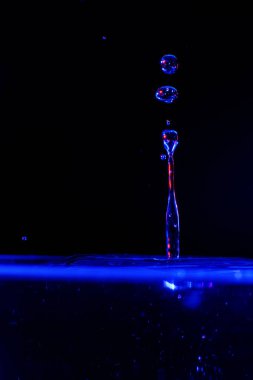 Siyah bir arka plan üzerinde renkli suda Sıçrama