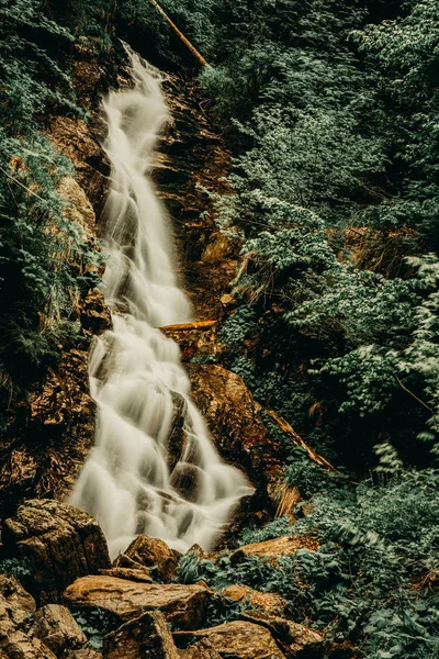 Mountain waterfall on the rock covered with moss in the forest