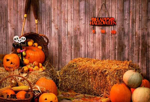 Pumpkin heads and autumn props on wooden background