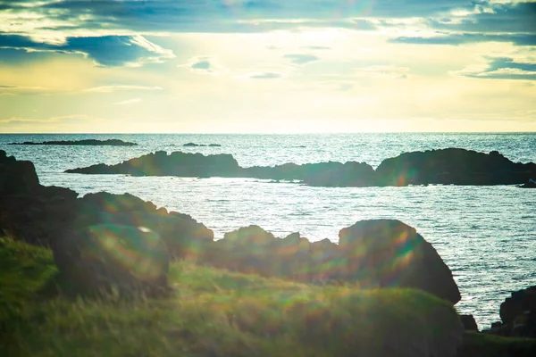İzlanda 'da Okyanus Ufkunu ile Güneş Işığı Altında Kayalık Kıyı