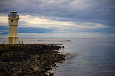 Kıyı feneri kayalık sahilde Bulutlu gökyüzü
