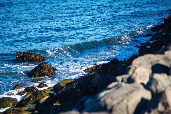 Kayalık sahilde okyanus dalgaları kırılıyor.