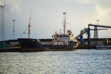 Endüstriyel kargo gemisi vinçlerle limana yanaştı.