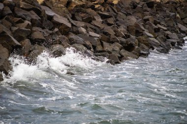 Okyanus dalgaları kayalık kıyı şeridine çarpıyor.