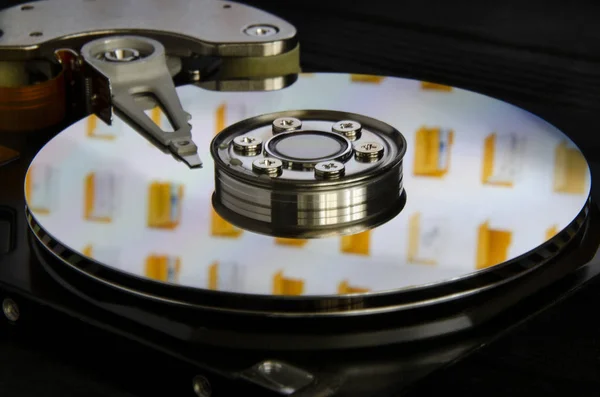 Disassembled computer hard disk. Displaying desktop folders from the monitor to the surface of the disk.