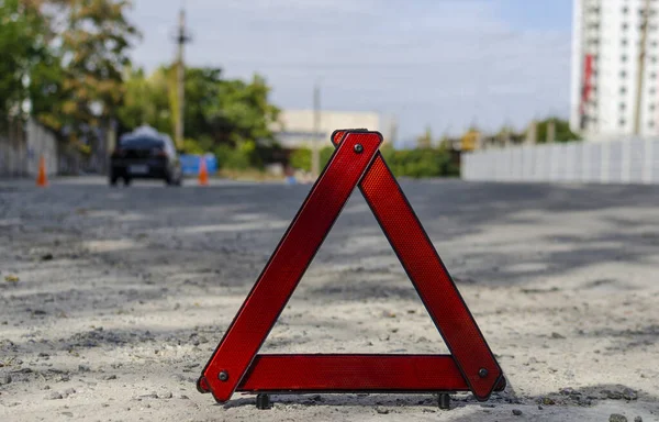 Red triangle, red emergency stop sign, red emergency symbol on road with sun light background.