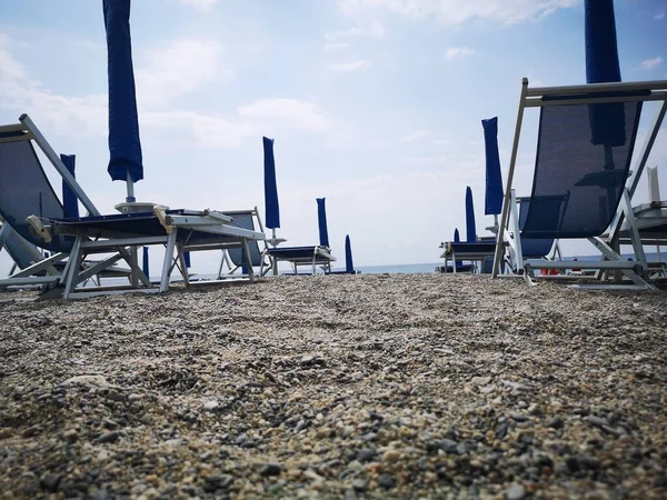 在珊瑚夏季 意大利海滩上的雨伞和甲板椅子的几何形状 — 图库照片