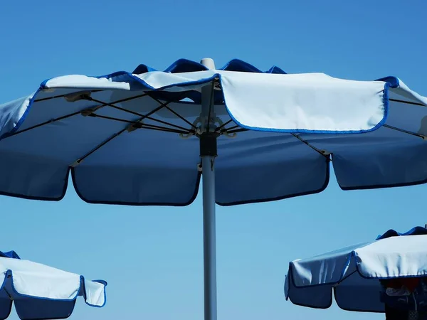 blue beach umbrellas in the sea of a liguria