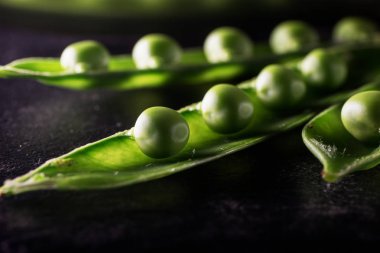 Üç pods bezelye karanlık masa yüzeyi ile.