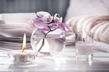Ev iç. Mufassal ile natürmort. Vazo, mumlar, çiçektir Beyaz ahşap masa, coziness ve okuma kavramı üzerinde açık kitap.