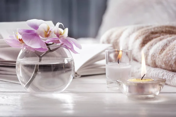 Orchidee in vaas volgende ot brandende kaarsen voor bed. Interieur. Stilleven met mede. — Stockfoto