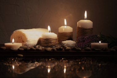 Güzel bokeh ile düşük anahtar Spa kavramı. Koyu ahşap arka plan üzerinde çakıl, tuz, çiçek ve havlu.