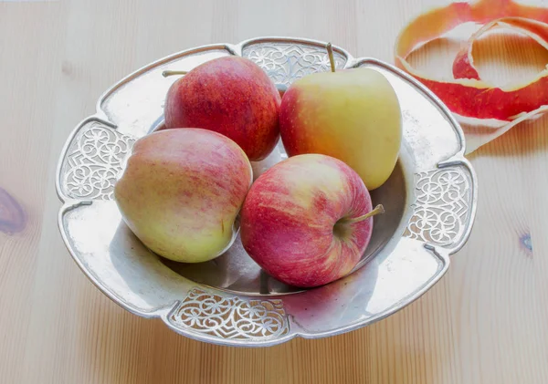 Four apples on silver opergne on wooden table — Stock Photo, Image