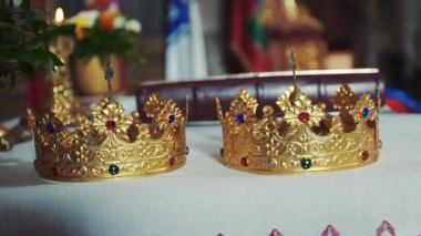 Altın kron sunak üzerinde vardır. Rahip özniteliklerini