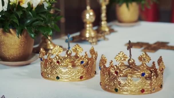 Atributos da igreja para cerimônia de casamento. Coroas de ouro na igreja — Vídeo de Stock