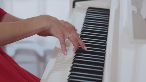 Молодая женщина играет на пианино — стоковое видео