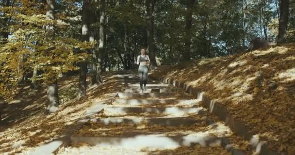 Mujer corredora preparándose para correr y comienza a correr con auriculares escuchando música — Vídeos de Stock