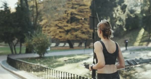 Спортивная модель фитнеса в спортивной беговой одежде с воздушными капсулами наушники наушники белые руки бесплатно подходят слушать музыку — стоковое видео