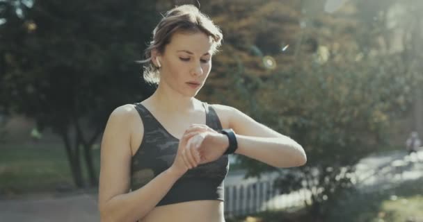 Fitness žena v bezdrátové sluchátka pomocí hodinek Smartwatch — Stock video