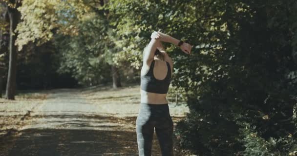 Бігунка жінка розігрівається і розтягується — стокове відео