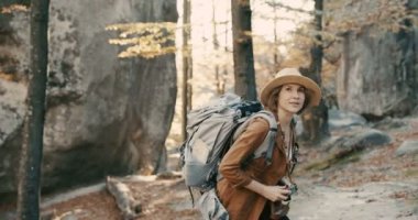 Kayalar bir orman üzerinde bir vintage film kamerası ile fotoğraf çekmek aktif sağlıklı beyaz bir kadın