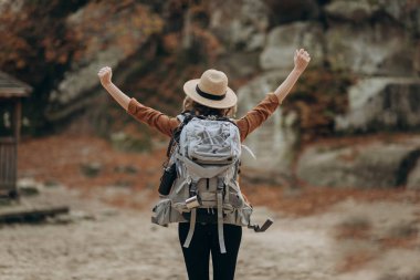 Dağın tepesinde rahatlatıcı, güzel sonbahar manzaraya bakarak kaldırdı elleriyle kız