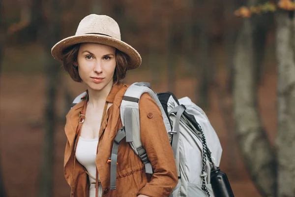 Retrato mujer viajero con mochila mirando bosque increíble — Foto de Stock