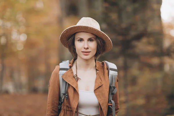 Ritratto donna viaggiatore con zaino guardando sorprendente foresta, concetto di viaggio, spazio per il testo — Foto Stock