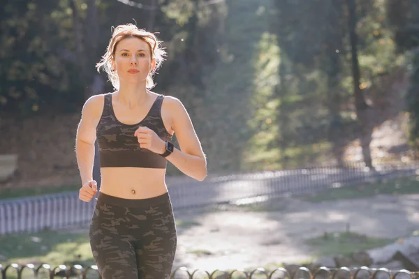 Runner femme commence à courir en portant des écouteurs écoutant de la musique — Photo