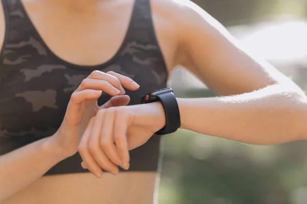 Mujer usando su smartwatch pantalla táctil dispositivo de tecnología portátil en las luces de la mañana — Foto de Stock