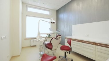 Lüks minimalist diş kliniği iç cam duvarlar üzerinde diş lamba kırmızı sandalye ve araçları,