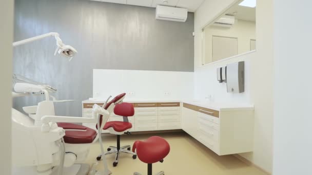 Lugar de trabajo del dentista con unidad dental y silla — Vídeo de stock