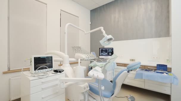 Стоматологическая клиника: комната со стоматологическим креслом и медицинским оборудованием — стоковое видео