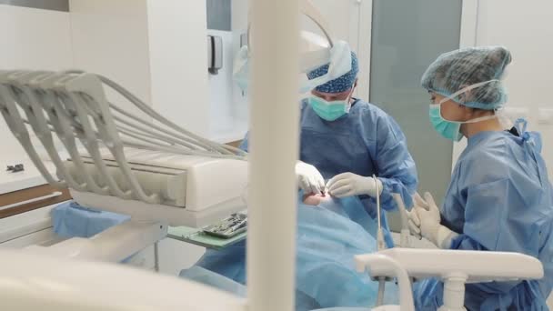 Красивий Чоловік Стоматологічному Кабінеті Двоє Лікарів Стоматолога Встановлюють Імплантати — стокове відео