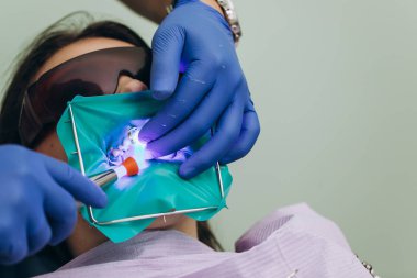 Diş kaplama. Seramik açık kron, yeşil arka plan