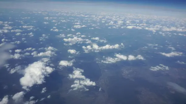 Błękitne niebo i chmury, patrząc przez okno samolotu — Zdjęcie stockowe