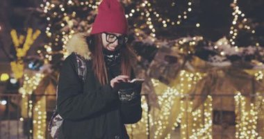 Şehirde, geceleri akıllı telefon kullanan kadın gece meşgul sokak ışıkları arka plan bulanık