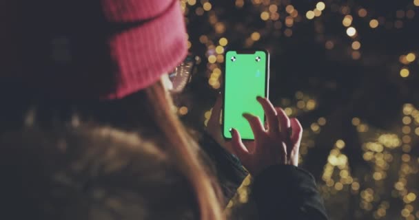 Το κορίτσι είναι χρησιμοποιώντας Smartphone με πράσινη οθόνη σε κατακόρυφο προσανατολισμό στο βράδυ. Casual τρόπου ζωής — Αρχείο Βίντεο
