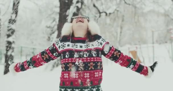 Mulher feliz na bela floresta de pinheiros no topo da montanha polvilhando neve no ar — Vídeo de Stock